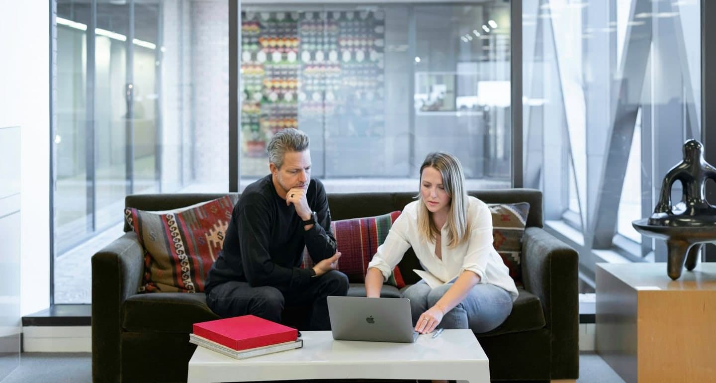 Two colleagues planning a marketing strategy on a laptop